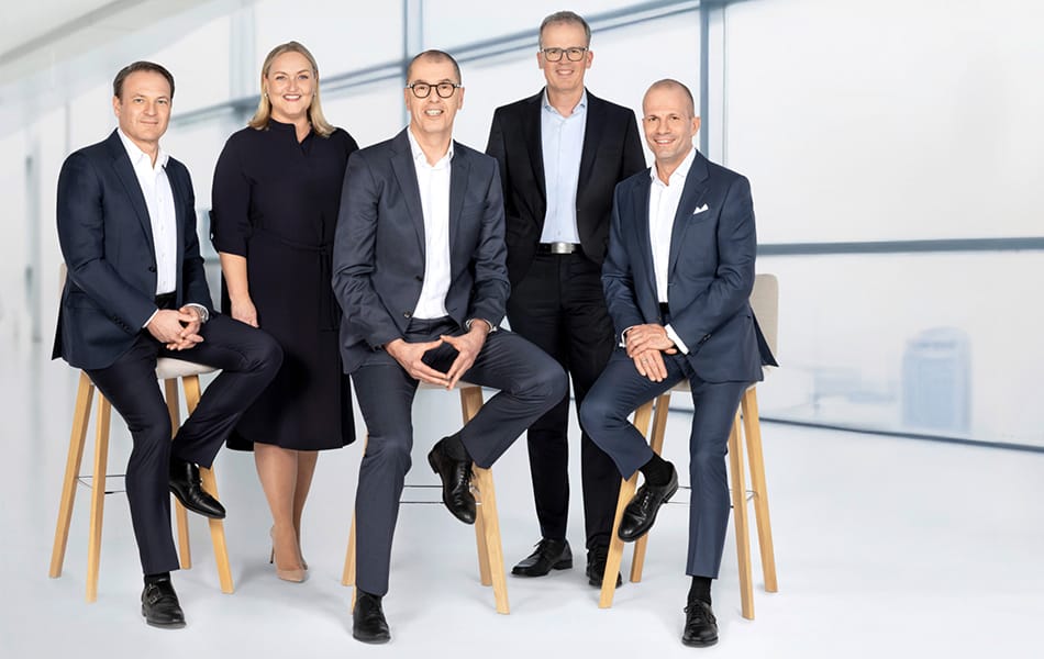 Querformatiges Gruppenfoto des Vorstands von Union Investment in einem hellen Büro.